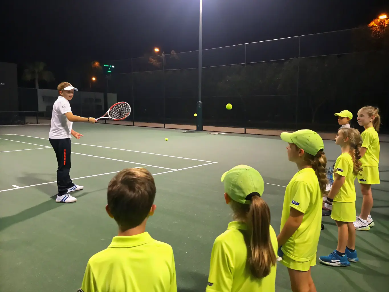 A vibrant image of adults participating in a group tennis lesson on a sunny court, focusing on proper form and technique, with the coach providing guidance.